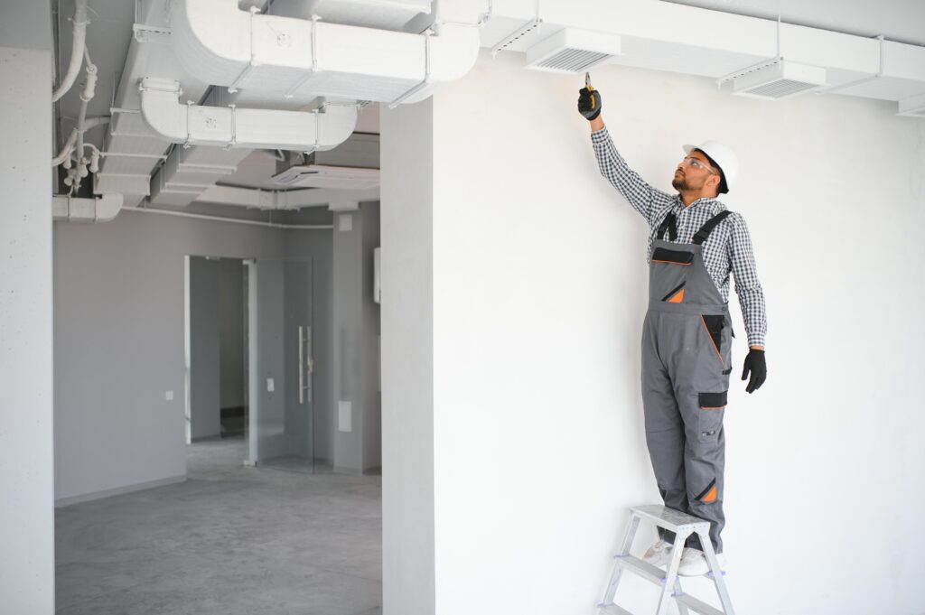 hvac services indian worker install ducted pipe system for ventilation and air conditioning in house